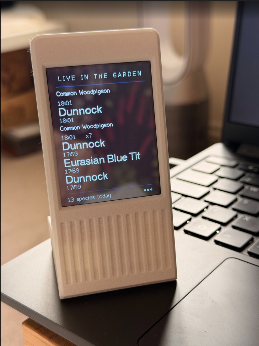 The original small LCD display in its white printed case, showing recent bird identifications under the heading Live in the Garden.